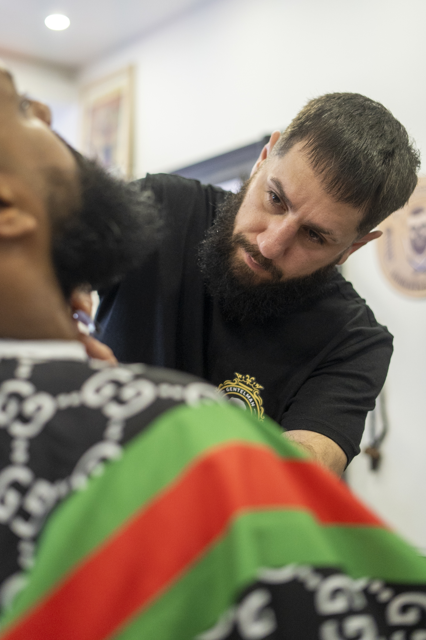 De barbier werkt een volle baard bij met de tondeuse